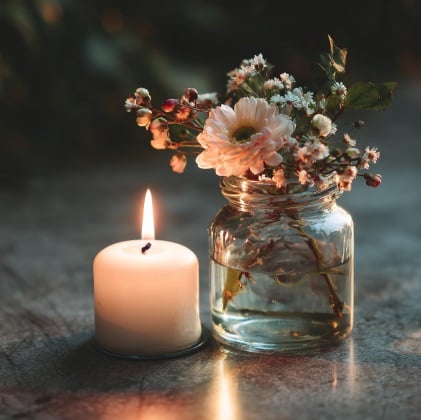 Candle and small floral arrangement representing remembrance and support for cremation services in Deltona, FL.